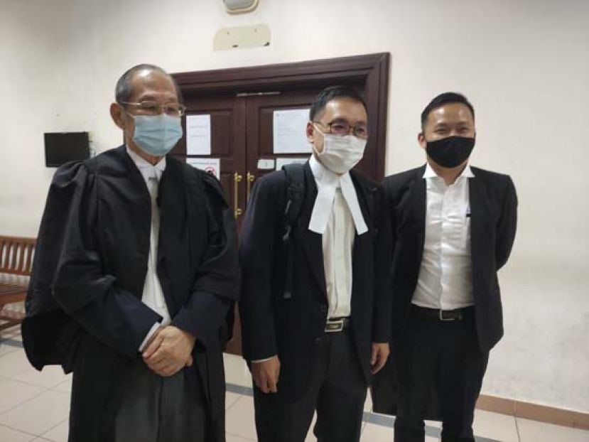 身兼律师和答辩人的张健仁（中）和父亲张守江及江峰年影于庭外。