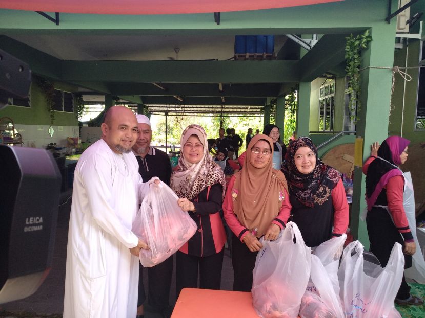 砂福利、社会和谐、妇女家庭与儿童发展部长拿督斯里陈赛明（左三）在分发牛肉给贫户。