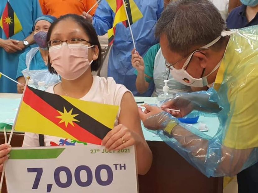 拿督斯里沈桂贤医生（右）为石角政府诊所第7000剂冠病疫苗接种者进行疫苗接种。