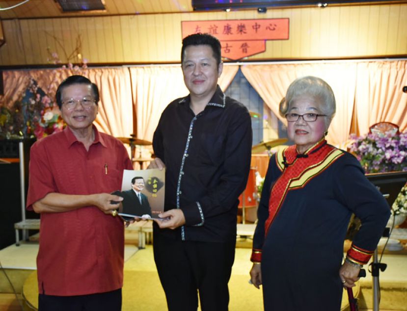 古晋友谊康乐中心法律顾问拿督叶金来（左一）赠送著作《那些年永恒回忆》予沙巴拿笃乐扬文娱社社长李伟雄（中）及古晋友谊康乐中心主席李金妹（右一）。