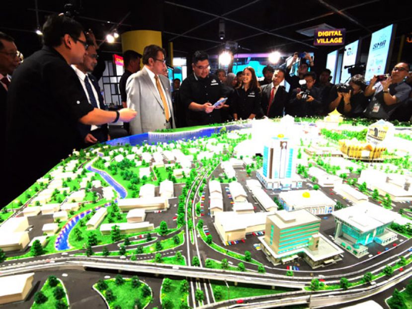 砂首长拿督巴丁宜阿邦佐哈里（中）观赏智能城市模拟造型。