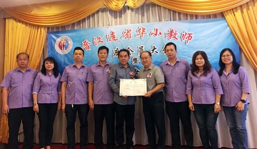 晋汉连省华小教师会大会上，主宾兼赞助人本曼查刘石星（左五）在晋汉连省华小教师会主席王芍强校长（左四）、署理主席黄玉祥（右三）等人见证下，颁发终身成就奖予该会名誉主席邓景文校长。