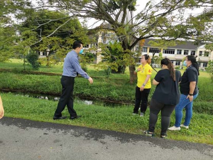沈雅诗(左2)向刘世坤校长(左1)讲解工程安排。
