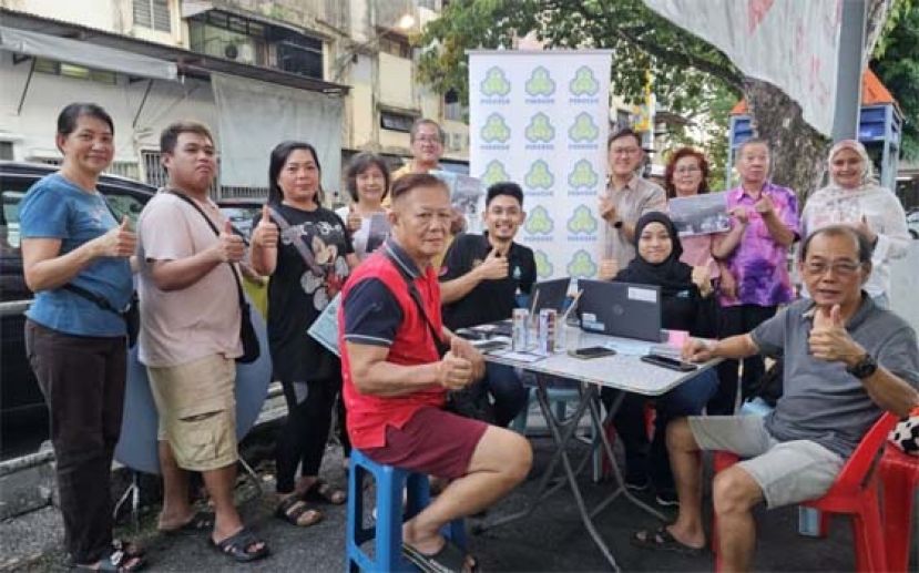 田福才（左5）及薛华东（右4）等人在社险于辉盛小贩中心柜台合影。
