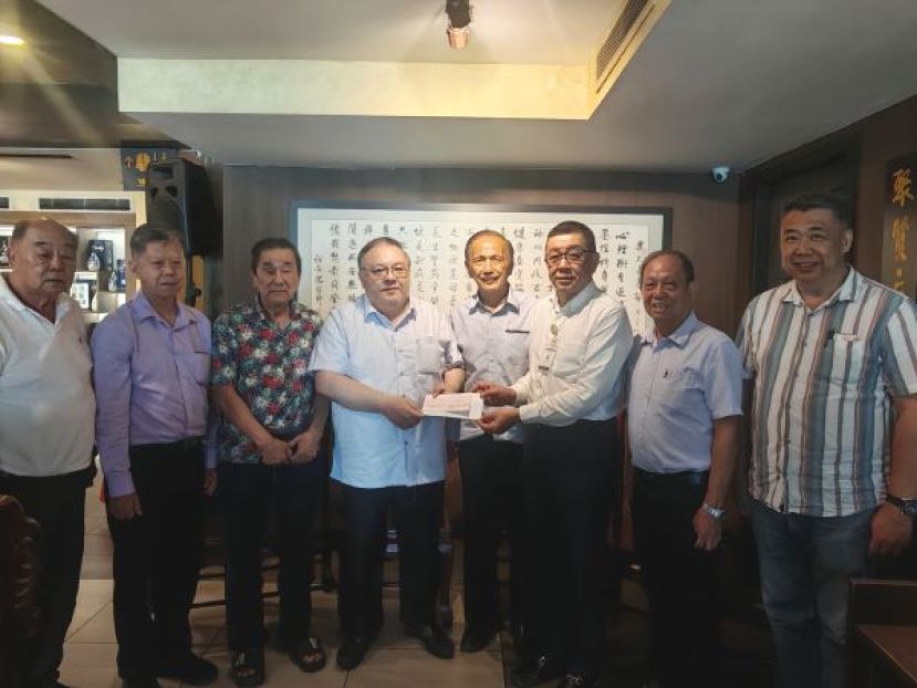 该基金主席拿督黄国忠（左4）移交教育款项予古晋中中校董会主席兼该基金秘书 拿督斯里黄良杰（右3）。左1起：董事吴祖姜、董事拿督陈日枝、财政黄张金发；右1起：副秘书周文盛、副主席甲必丹蔡永能、署理主席拿督余志豪。