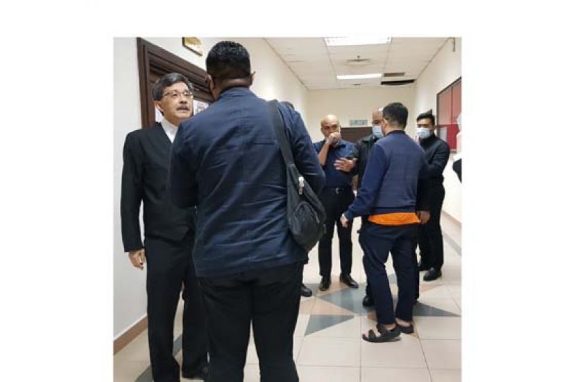 律师嫌犯在法庭走廊外等候过堂。