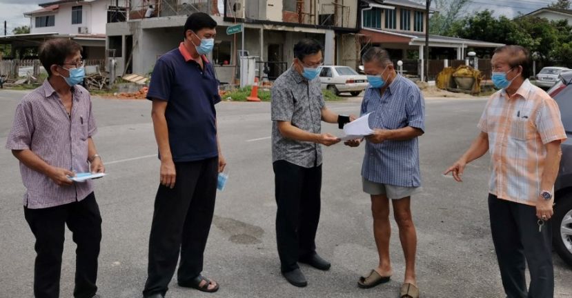 砂盟峇都林当区候选人薛华东（中）忙于竞选也忙服务人民；右为本固鲁严安干。