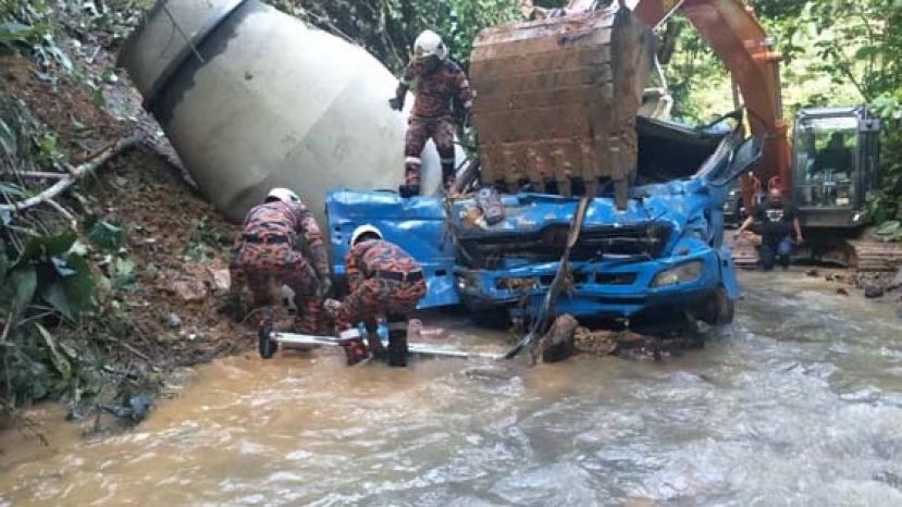 消拯人员在10米深溪边斜坡处，以挖泥机稳住洋灰搅拌车，准备取出尸体。