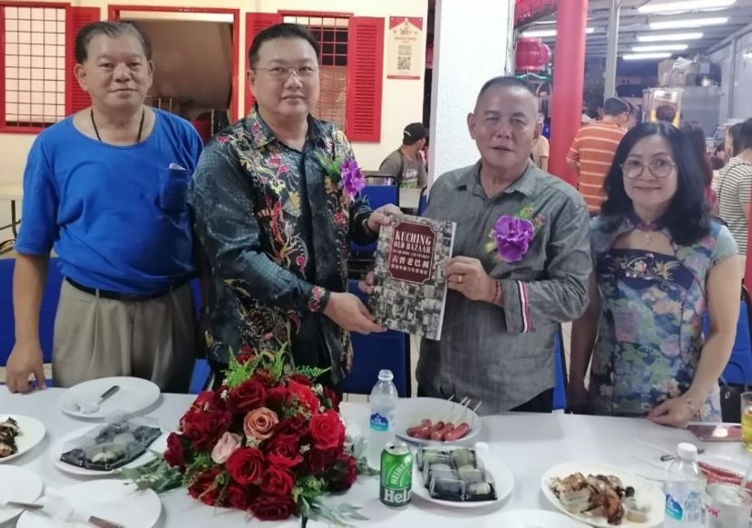 甲必丹林传政赠书予王运才博士；左为陈中兴；右是甲必丹许碧珠。