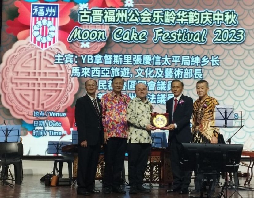 古晋福州公会会长拿督余志豪(右二)移交纪念品予拿督斯里张庆信的代表拿督刘思乐时摄。左起为该会乐龄组主任林启禄以及署理会长王长福。右一为筹委会主席陈联褒。