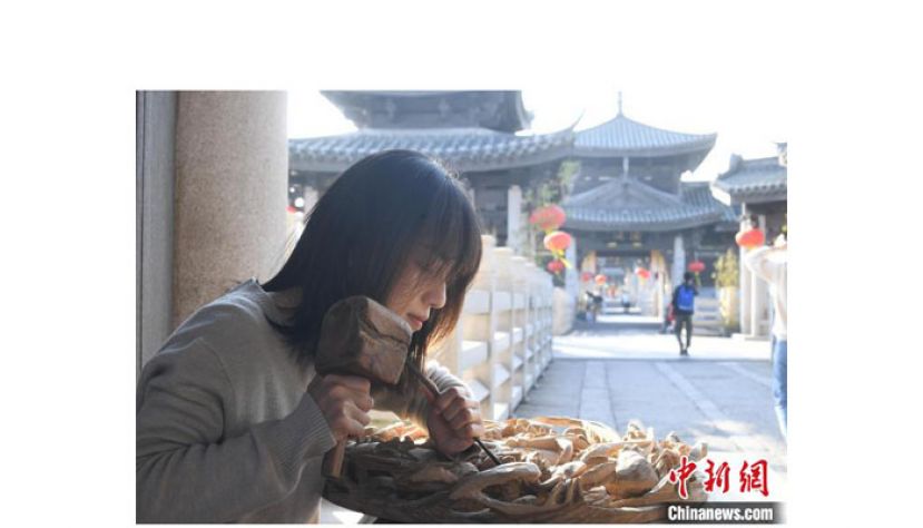 潮州木雕传承人陈嘉在广济桥上做木雕。