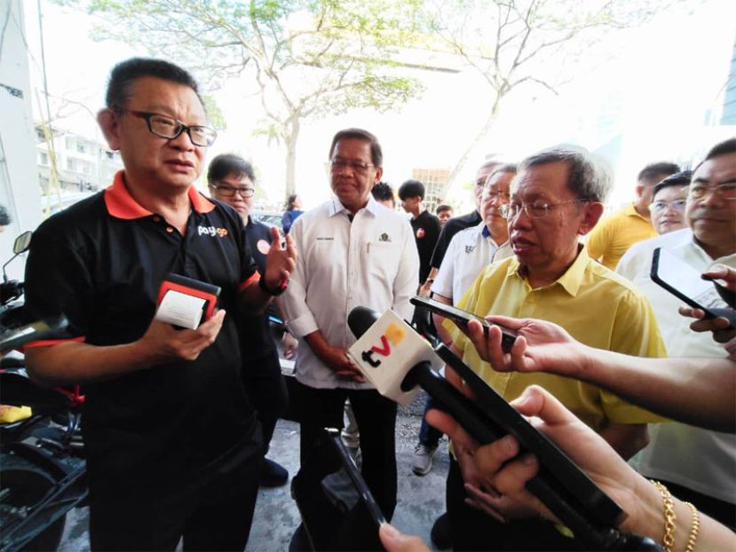 “Pay &amp; Go”创办人兼科技首席执行员黄德东（左）向砂拉越副总理拿督阿玛沈桂贤解说“Pay &amp; Go”系统操作。