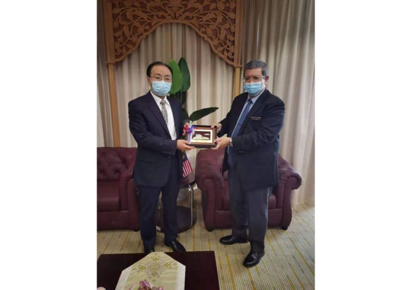 通讯及多媒体部长拿督赛夫丁(右)与中国驻马大使欧阳玉靖相互交换纪念品。