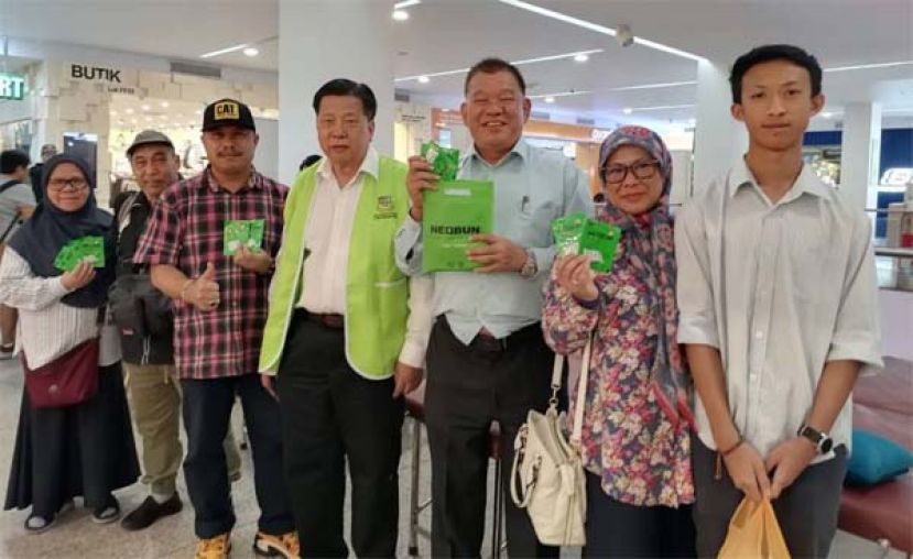 砂医总会长江宗兴（左四起）及会务顾问陈中兴在美里义诊现场施医赠药派发&ldquo;脱苦宝&rdquo;药贴予参与民众。