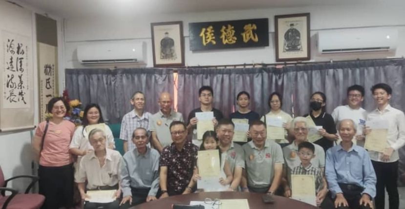 学生从执行委员手中接过奖品，前排主席沈茂强（中间），从左至右依次为福利专员沈瑞琪、秘书沈耀发和副主席拿督沈坚石。从右至左依次为：助理秘书沈锦宝、财务主管沈榜松和副主席沈奇王豪。