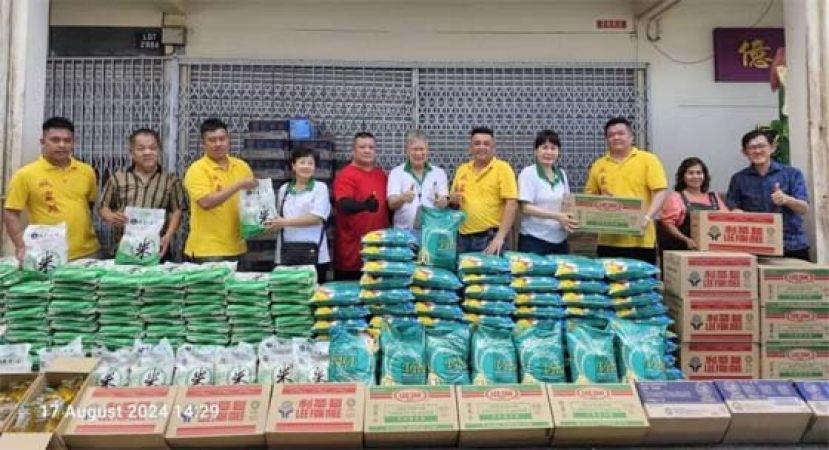 祥云斋负责人黄松熙（右6）等人由炉主胡桂宾（右6）及热心善信者手中接过白米及食品赠品；右为薛华东。