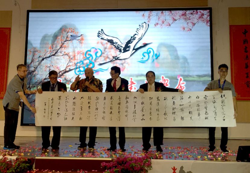 中国书法大师杨再春教授（左3）赠送亲笔题写的墨宝予中国驻古晋总领事程广中（右3），左2及右2分别为大会主席杨添木及闲云野鹤书法学会总顾问蔡振强。