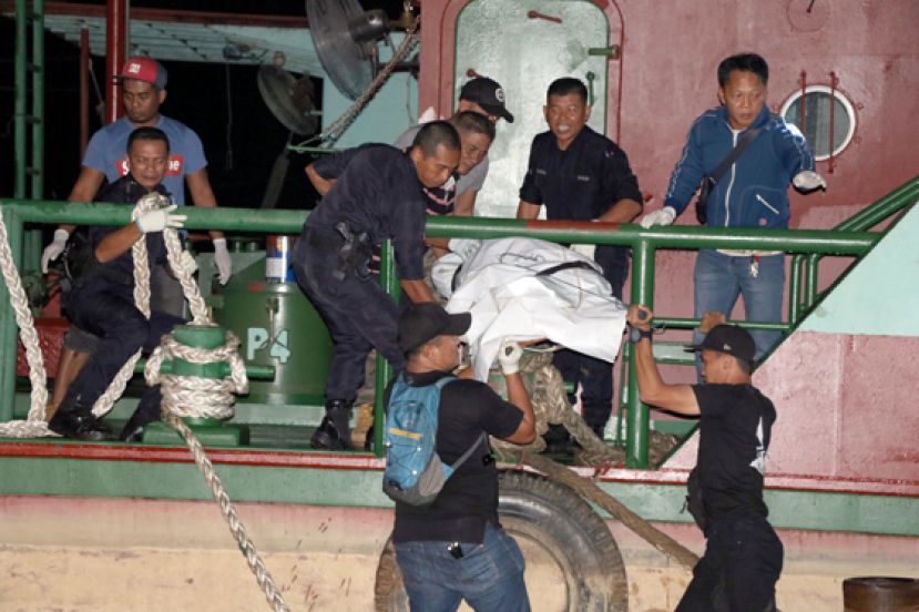 警员合力将身上捆绑着十余片砖块的尸体从船上抬上码头。