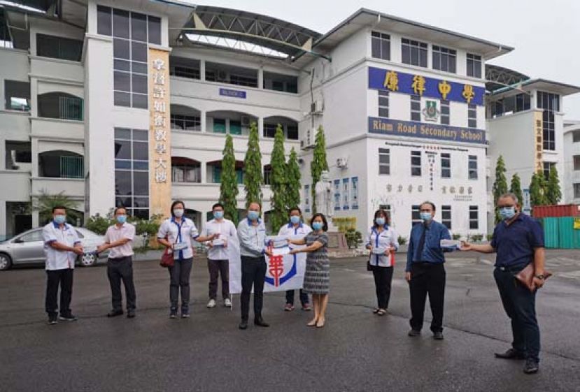 拿督吴健平(左5)与理事们移交教育金拨款及口罩予廉律中学首席执行员何宝玲(右4)与老师们。