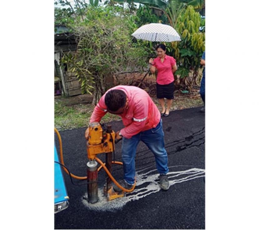 石角金珠盛第5巷道路提升工程完工，使用测量器探测有关道路的沥青厚度。张健仁特别助理周宛诗在一旁监督。