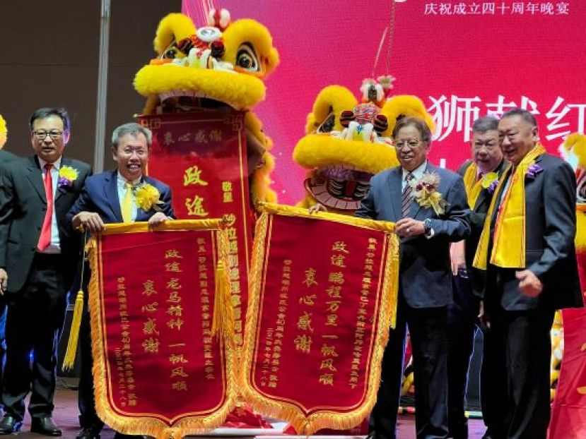 在世界沈氏宗亲会联谊会总会印尼代表沈天仁（右一）、马来西亚沈氏总会总会长兼砂拉越潮州沈氏公会会长沈茂强（右二）、该会第二副会长沈坚石 （左一）的陪同下，砂总理阿邦佐哈里（右三）和砂副总理沈桂贤（左二）接彩时影。