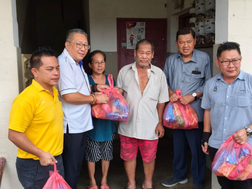古晋南市市长拿督黄鸿圣（左二）与副市长拿督南市副市长拿督再迪苏海里（右二）派发物资予受惠的居民，右一为郑志国市议员，左一为郑神彬。
