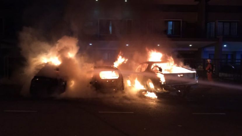 三辆停放在屋外的轿车起火燃烧。