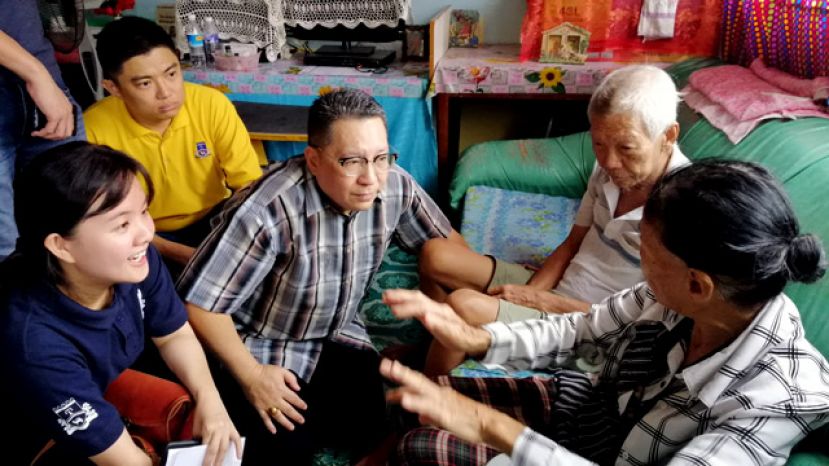 (左2)新任古晋南市市长拿督黄鸿圣坐在地板上耐心聆听贫苦人家的心声。