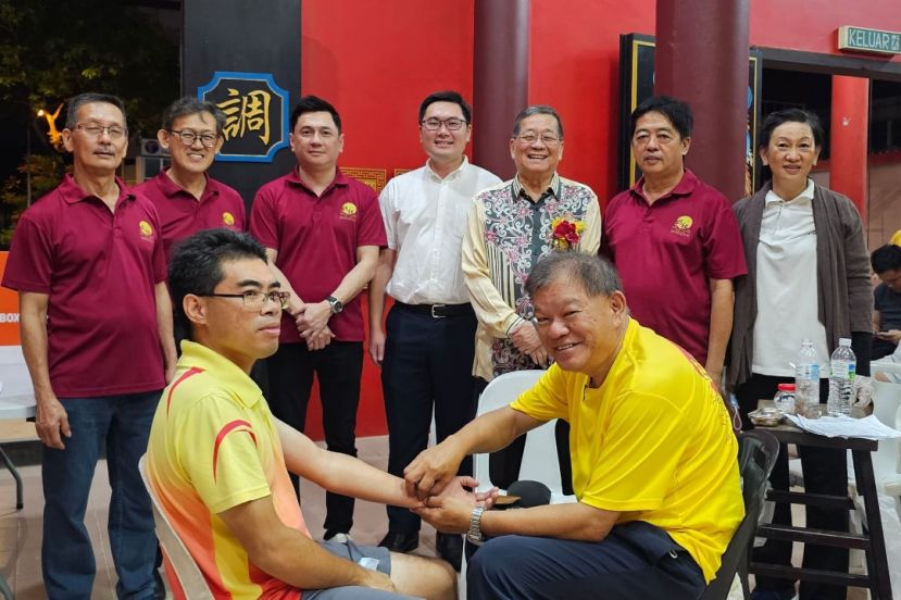 拿督邓伦奇（右3起）在黄笃荣、庆典筹委主席马可倧、顾问薛华东、林树忠及许爱丽医师（右起）、庆典大会会长许义华陪同，观看中医义诊筹委主席陈中兴为一民众服务。