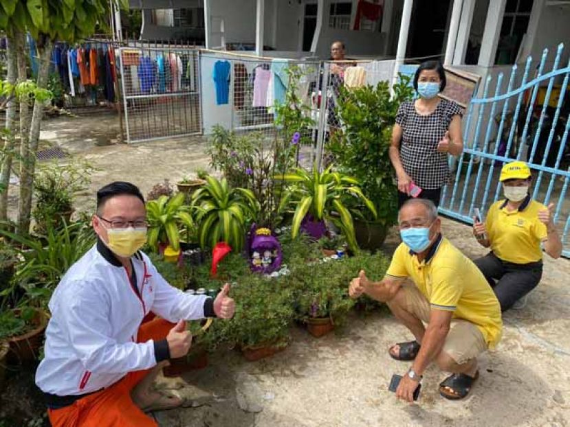 冠军黄桂妹（右一）用洗衣液瓶子剪出漂亮的容器种植花卉。