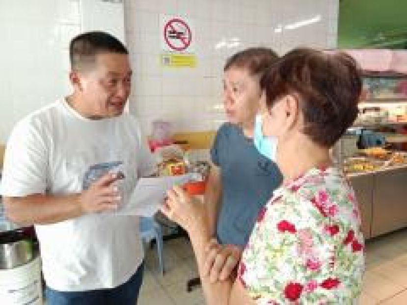 巴都林当区议员施志豪（左）与民众分享"砂年长者健康福利"（SCHB）的惠民用途。