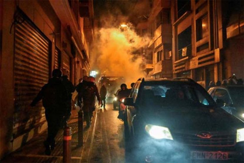 防暴警察抛出催泪瓦斯后，在烟雾中疾步离开现场。