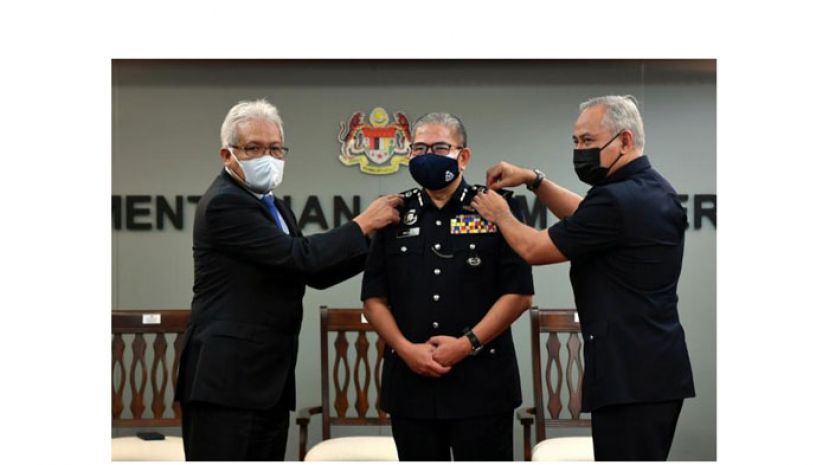 内长韩沙再努丁(左)为玛兹兰配戴警勋(中)。