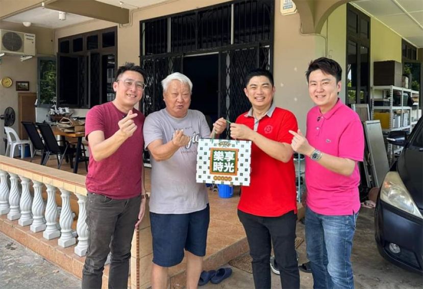 一中校友会副会长刘世栋（右二）送礼品予陈天财老师。左一为张峰泰校友。右为涂智斌校友。