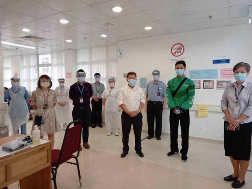 拿督斯里沈桂贤（中）及砂中央医院院长严慧文（右）向首批冠病疫苗临床研究测试志愿者加油打气。