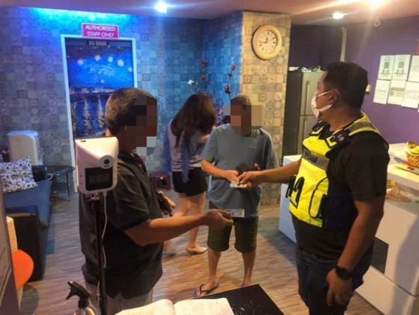 警方在突击行动之中检查相关人士的身份。