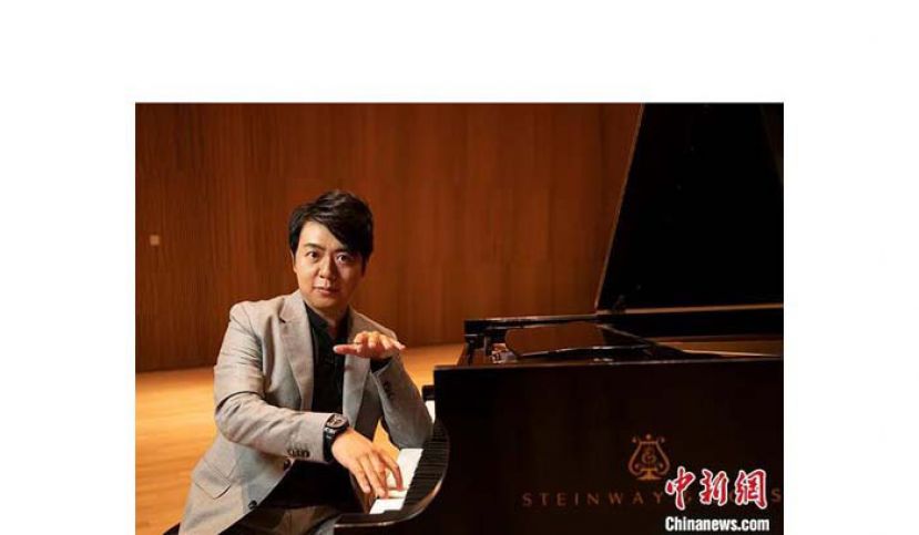 郎朗接受专访当日在钢琴旁面对记者镜头。
