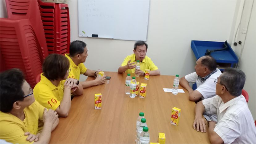沈桂贤（中）与味源港慈云善信会理事交流。右是理事会主席张源有，左为人联党石角支部主席林亚德。