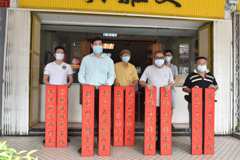 闲云野鹤书法学会举办《辛丑千家万户贴春联》春联义卖推展礼。活动大会顾问杨添木（右三）与筹委展示春联。左起为筹委会协调杨振祥、筹委会主席蔡汉民及筹委会财政陈瑞隆；右起为筹委会交通物流李汉标及筹委会策划刘文葆。