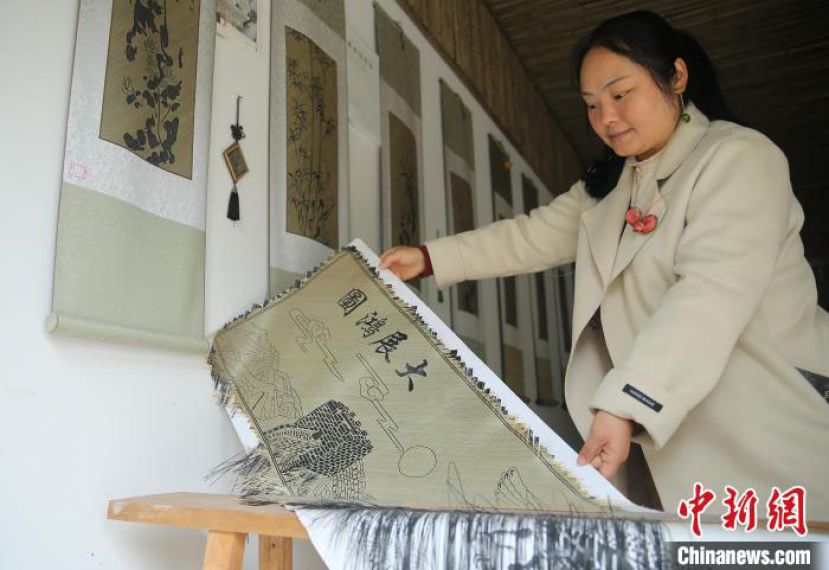 袁朝秀展示她正在编织的平面作品&ldquo;大展鸿图&rdquo;。