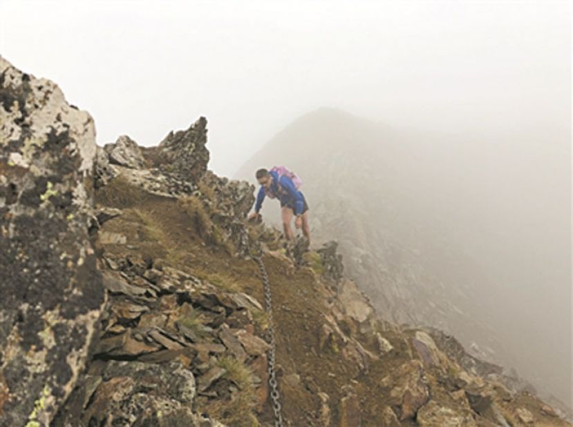 越野比赛中，林海丹在陡峭的山壁上前行。