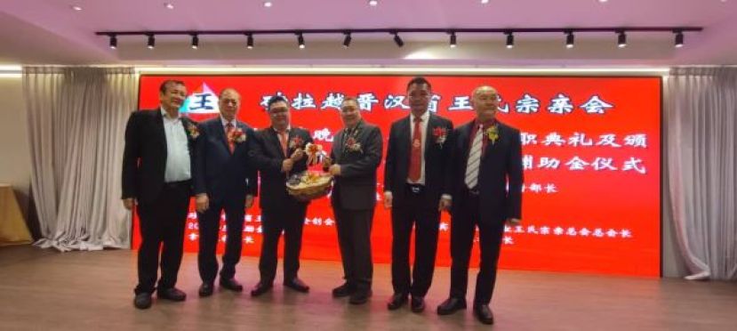 在众嘉宾的陪同下，筹委会主席王德锋（左三）赠送纪念品予主宾拿督黄鸿圣时影。