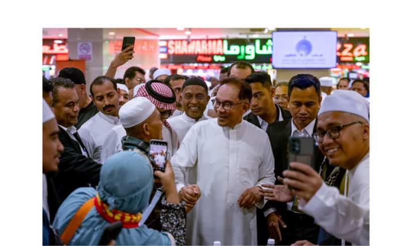 首相安华与旅居沙地的商家握手寒暄。