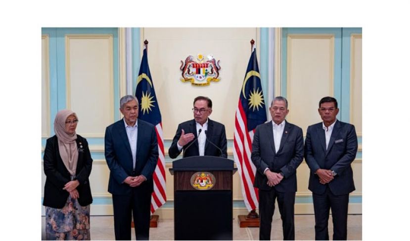 首相安华(中)在一众部长陪同下召开新闻发布会。