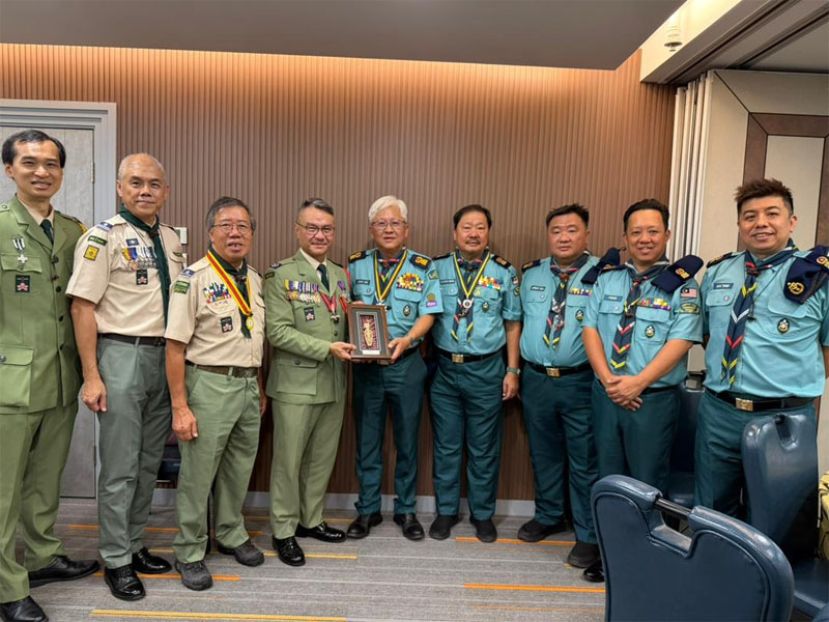 在代表团团员见证下，砂拉越首席童军总监林文明（右）向香港童军总会总监黎伟生博士（左四）赠送纪念品，象征双方深厚的友谊与合作精神。