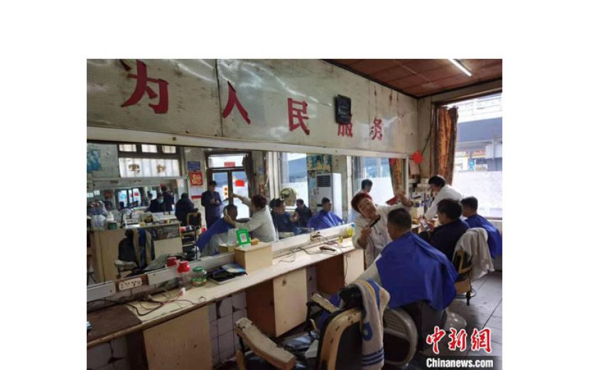 华义美发厅内贴着&ldquo;为人民服务&rdquo;的大字。