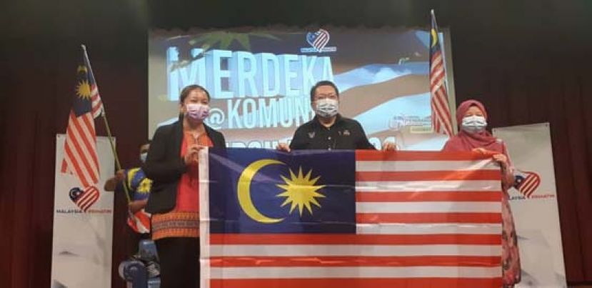 古晋南市市长拿督黄鸿圣（中）主持砂拉越新闻局所主办的古晋社区国庆日活动。