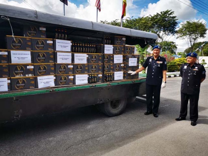 砂第5区水警指挥官桑苏卡欣（右二）展示起获的200箱逃税黑啤。