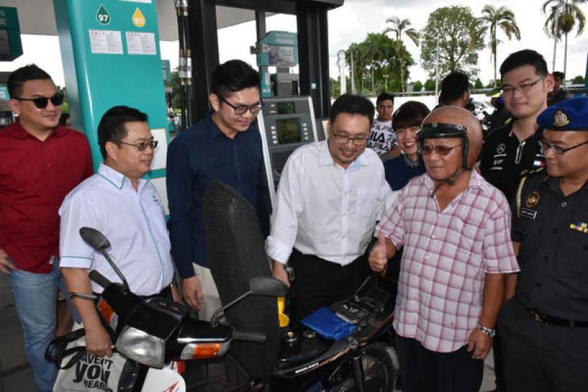 联邦贸消部副部长张健仁（右三）为电单车骑士提供免费添购5令吉 Ron 95免费汽油。