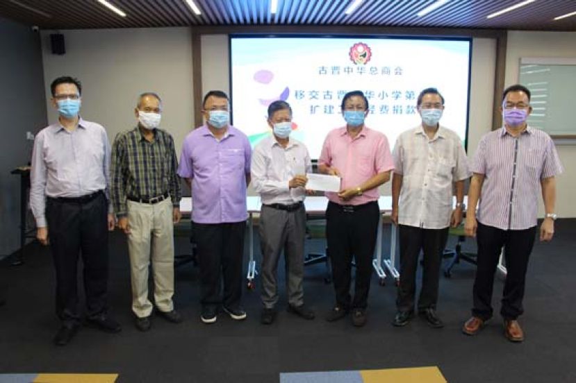 古晋中华总商会会长拿督陈日枝（中）移交5万令吉予古晋中华小学校董会主席拿督王长福（右三），左起古晋中华总商会财政何修华、副会长高伟宁和商会秘书长兼晋汉连省津贴华小董联会会长蔡文铎，右起校董会秘书长田松茂、副会长兼二小副主席兼二小扩建工程筹建会主席张光福。